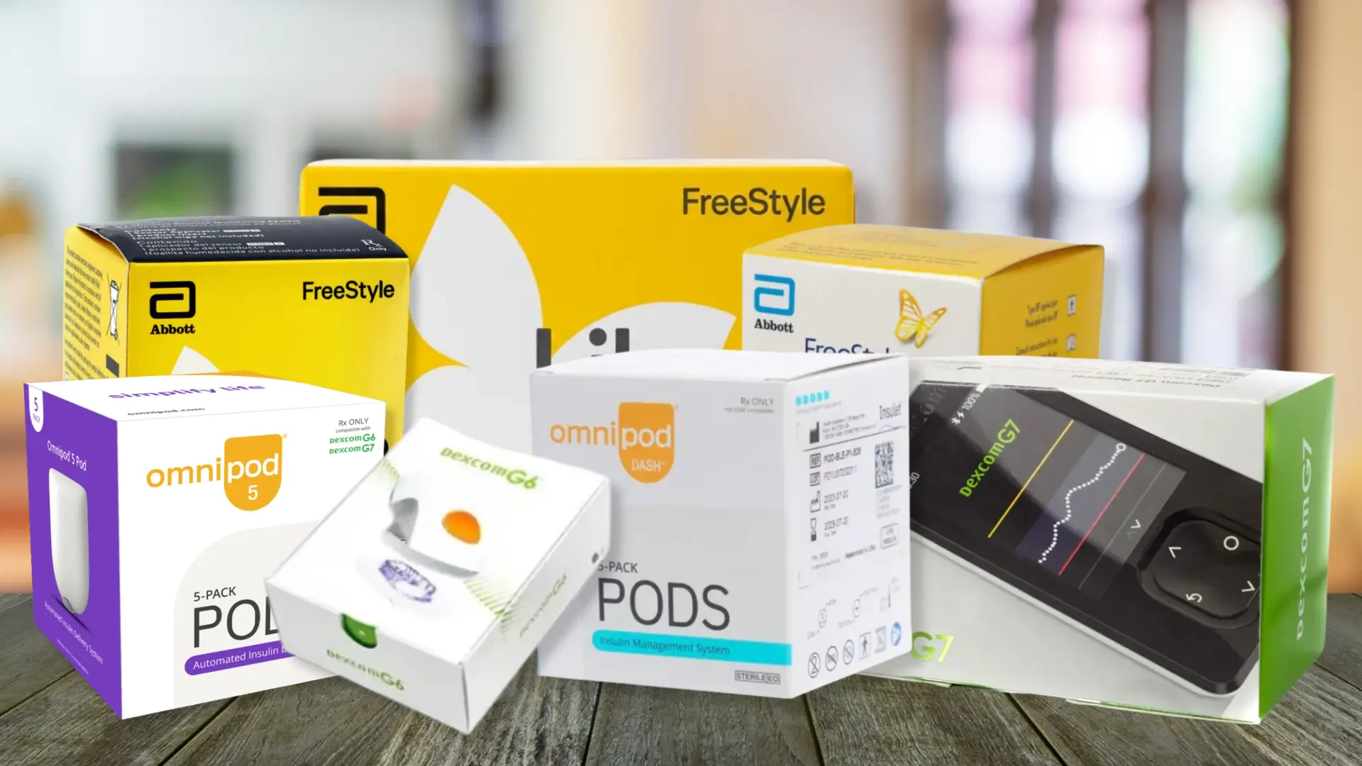 Diabetic supply boxes from Abbott FreeStyle, Omnipod and Dexcom arranged on a wooden table